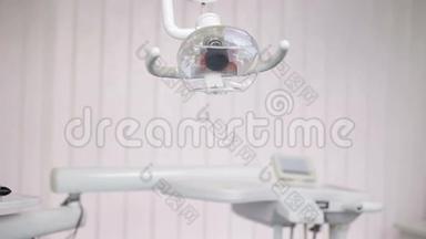 牙科灯架旁边的牙科椅和工具正在使用的牙医。